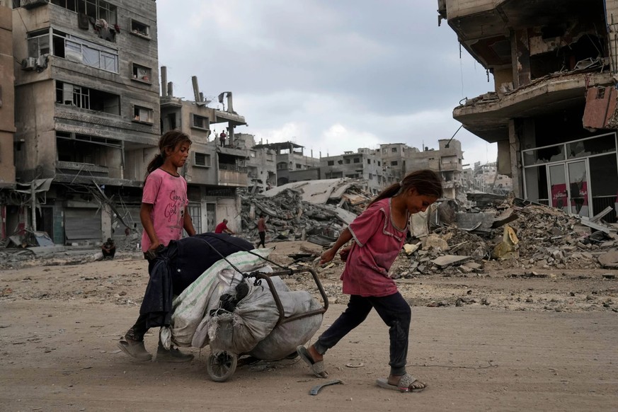 Deux jeunes filles palestiniennes transportent leurs biens à travers la ville de Gaza.