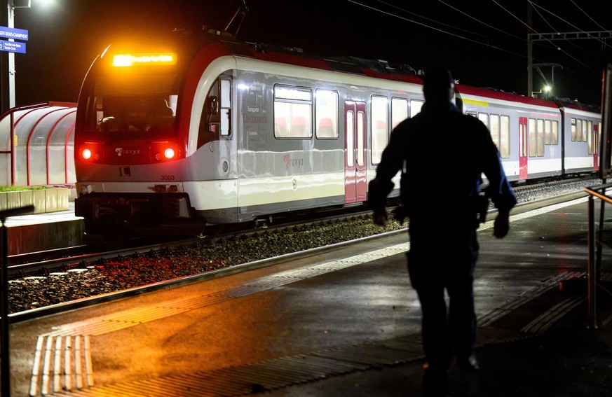 Vaud cantonal police officer watchs the Travys train where a hostage-taking incident took place at Essert-sous-Champvent station, Switzerland, Thursday, 8, February, 2024. A hostage-taking incident to ...