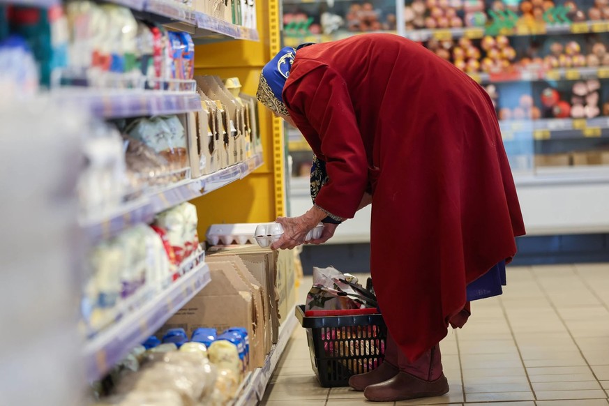 Une femme âgée fait ses courses dans un supermarché russe en pleine période d&#039;inflation galopante.