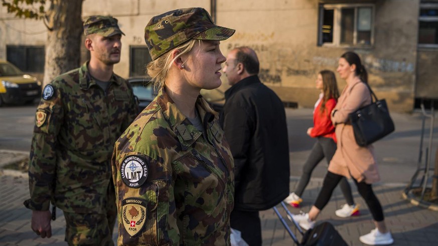 Le Lieutenant Mirko Della Pietra et la soldate Rea Tanner, membres d&#039;une equipe de liaison et de surveillance, LMT, (Liaison and Monitoring Teams) marchent dans les rues de la ville pour discuter ...