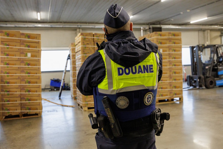 epa12667237 A customs officer guards a shipment of bananas for inspections to find illegal narcotics in a container during a press conference by the General Administration of Customs and Excise on the ...