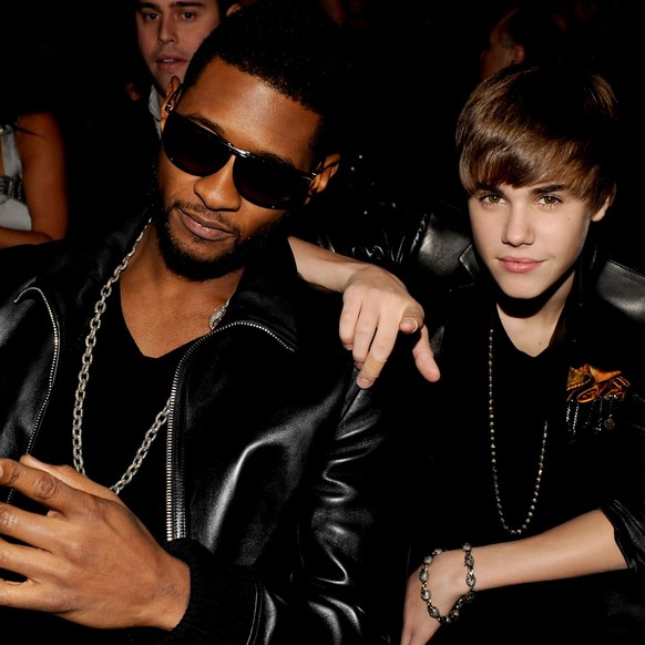 LOS ANGELES, CA – NOVEMBER 21: Musician Usher (L) and musician Justin Bieber pose in the audience during the 2010 American Music Awards held at the Nokia Theater LA Live on November 21, 2010 in...