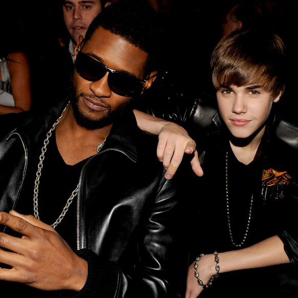 LOS ANGELES, CA - NOVEMBER 21: Recording artist Usher (L) and musician Justin Bieber pose in the audience during the 2010 American Music Awards held at Nokia Theatre L.A. Live on November 21, 2010 in  ...