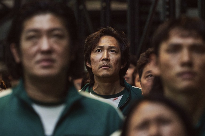 This image released by Netflix shows Lee Jung-jae, background center, in a scene from the popular Korean series &quot;Squid Game.&quot; Jung-jae was nominated for an Emmy Award for best lead actor in  ...