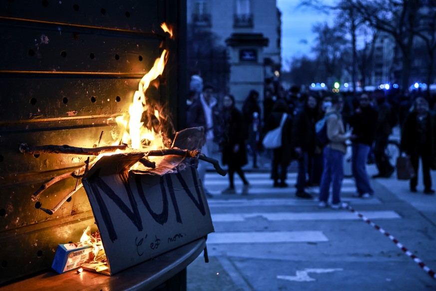 epa10534217 A placard that reads &#039;No&#039; burns during a demonstration against the government pension reform at Vauban square in Paris, France, 20 March 2023. Protests continued in France after  ...