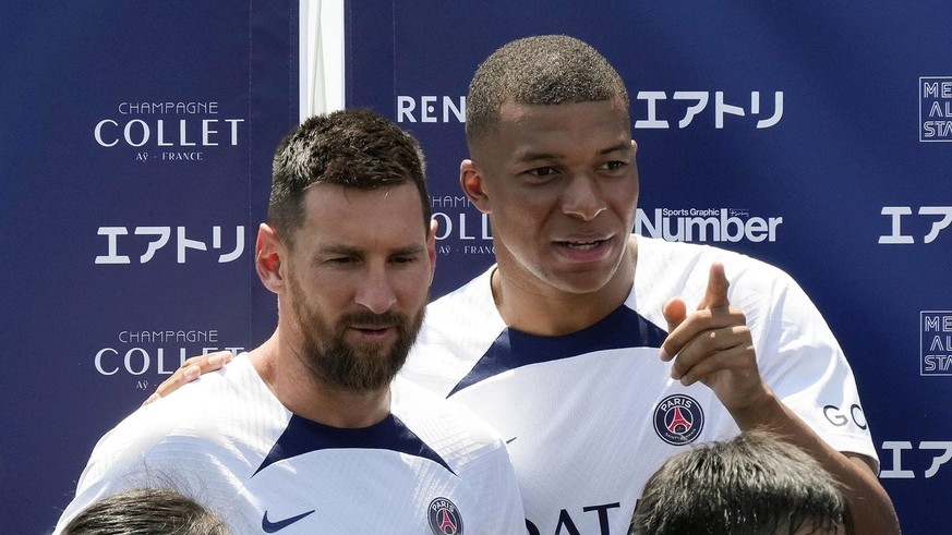 epa10077150 Paris Saint-Germain (PSG) F.C. players Kylian Mbappe (R) and Lionel Messi (L) chat during the PSG kids soccer clinic in Tokyo, Japan, 18 July 2022. Paris Saint-Germain will play three matc ...