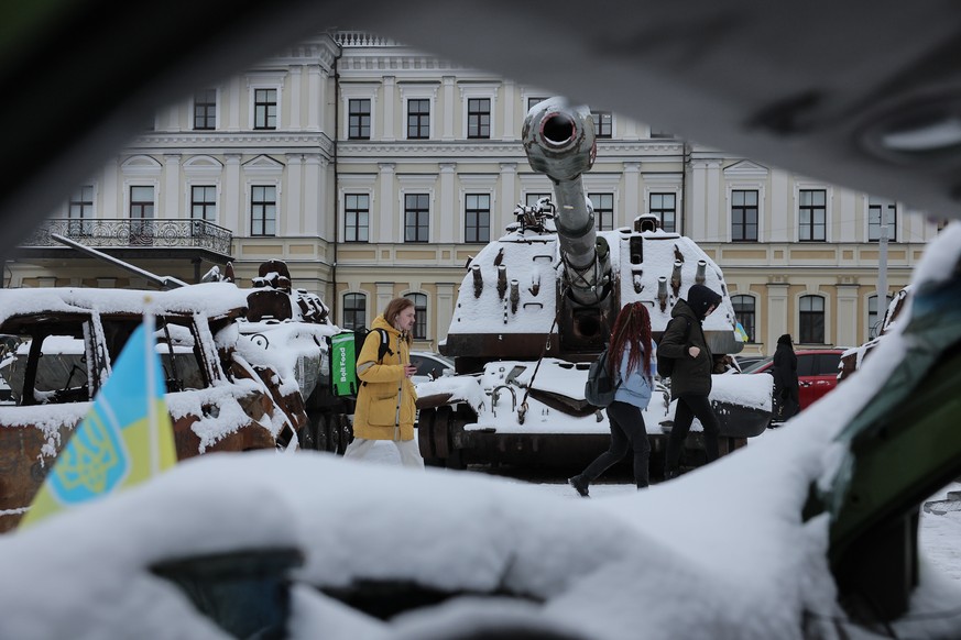 epa10989550 People walk beside destroyed Russian armored vehicles during the first snowfall of winter in Kyiv, Ukraine, 22 November 2023. Russian troops entered Ukrainian territory in February 2022, s ...