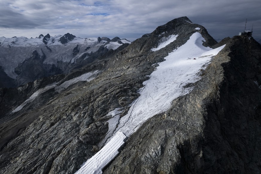 Blick auf den Corvatsch-Gletscher, waehrend Mitarbeiter der Bergbahnen Gletscher-Schutzvlies entfernen, aufgenommen am Montag, 5. September 2022, in Samedan. Das Schweizerische Gletschermessnetz