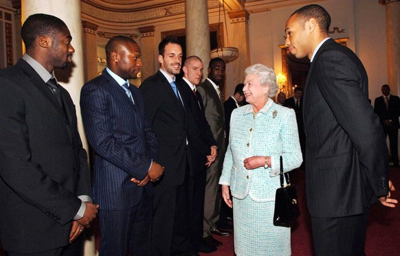 Britain&#039;s Queen Elizabeth II meets members of the English Premier League soccer team Arsenal, from left, Kolo Toure, William Gallas, Manuel Almunia, Philippe Senderos and captain Thierry Henry, r ...