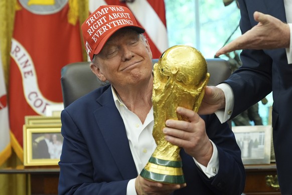 KEYPIX - President Donald Trump holds the FIFA World Cup Winners Trophy during an announcement in the Oval Office of the White House, Friday, Aug. 22, 2025, in Washington. (AP Photo/Jacquelyn Martin)
