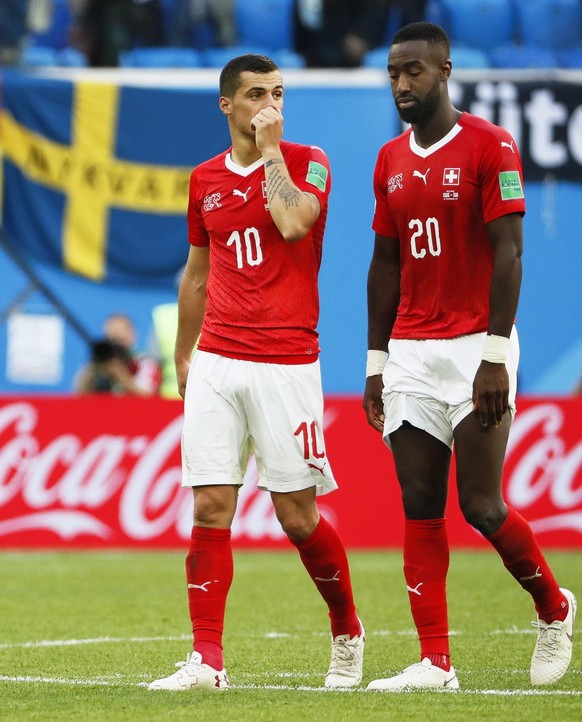 epa06861451 Swiss players Granit Xhaka (L) and Johan Djourou (R) react after the FIFA World Cup 2018 round of 16 soccer match between Sweden and Switzerland in St.Petersburg, Russia, 03 July 2018. Swe ...