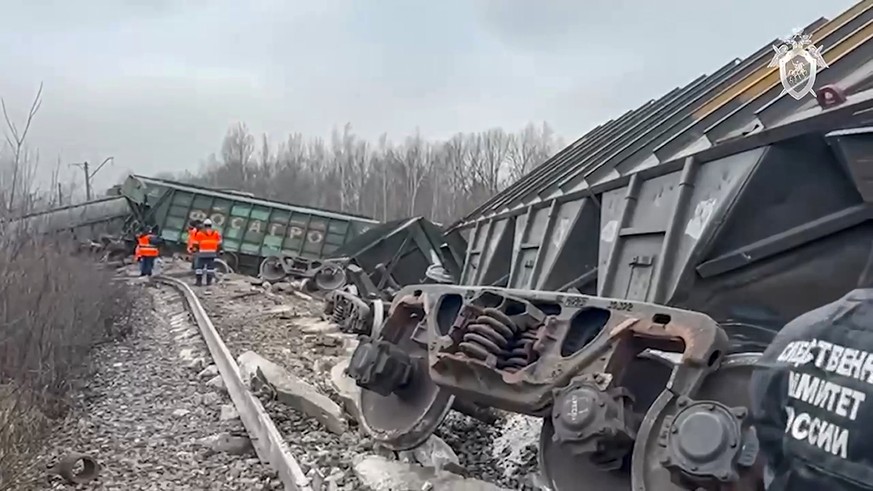In this handout photo taken from video released by Investigative Committee of Russia on Saturday, Nov. 11, 2023, Russian Railways Company employees work at the side of derailed train carriages carryin ...