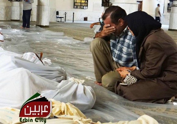 This citizen journalism image provided by the Local Committee of Arbeen which has been authenticated based on its contents and other AP reporting, shows Syrian citizens mourning over the dead bodies o ...