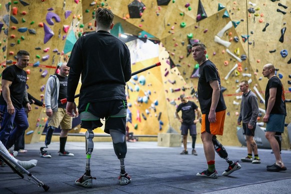 Former Ukrainian service personnel, some of whom lost limbs while fighting in the war against Russia, warm up together ahead of an indoor climbing session at Climbing SPACE in Kyiv on February 26, 202 ...