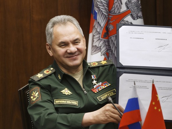 FILE - In this photo released by the Russian Defense Ministry Press Service, Russian Defense Minister Sergei Shoigu shows his signature under a roadmap for military cooperation between Russia and Chin ...