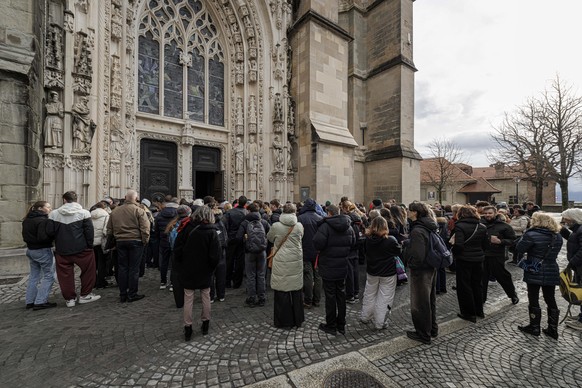 epa12638566 People wait in line to attend a commemorative ceremony on the national day of mourning following the deadly fire at the 'Le Constellation' bar in Crans-Montana at the Lausanne Ca ...