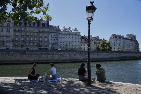 People sit in the shade along the Seine river in Paris, Sunday, June 29, 2025. (AP Photo/Michel Euler)
France Weather