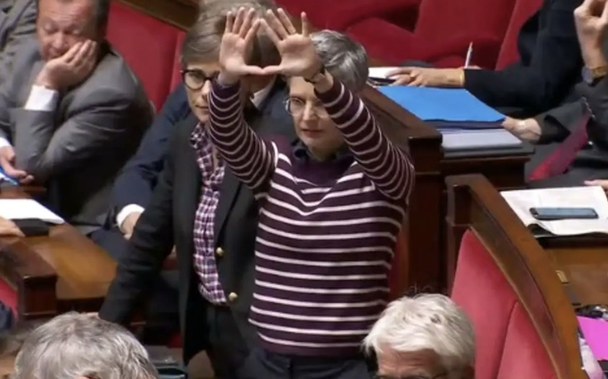 Sandrine Rousseau à l'Assemblée nationale, faisant le signe du sexe de femme inversé, un geste féministe. Paris, 4 octobre 2022.