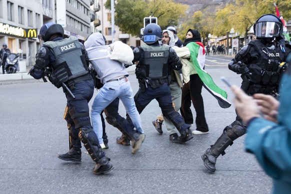 Des policiers antiemeute embarquent une personne lors d&#039;un rassemblement non autorise en solidarite avec le peuple palestinien ce samedi 1 novembre 2025 a Sion, en Suisse. (KEYSTONE/Cyril Zingaro ...
