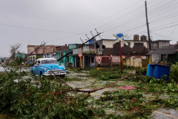 epaselect epa10210512 A car drives through debris on the street after the passage of Hurricane Ian, in Pinar del Rio, Cuba, 27 September 2022. Ian made landfall in western Cuba as a category 3 hurrica ...