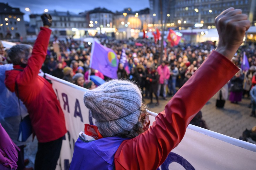 Des femmes brandissent leur poing lors d&#039;une manifestation lors de la journee internationale des droits des femmes ce mercredi 8 mars 2023 a Lausanne. (KEYSTONE/Laurent Gillieron)