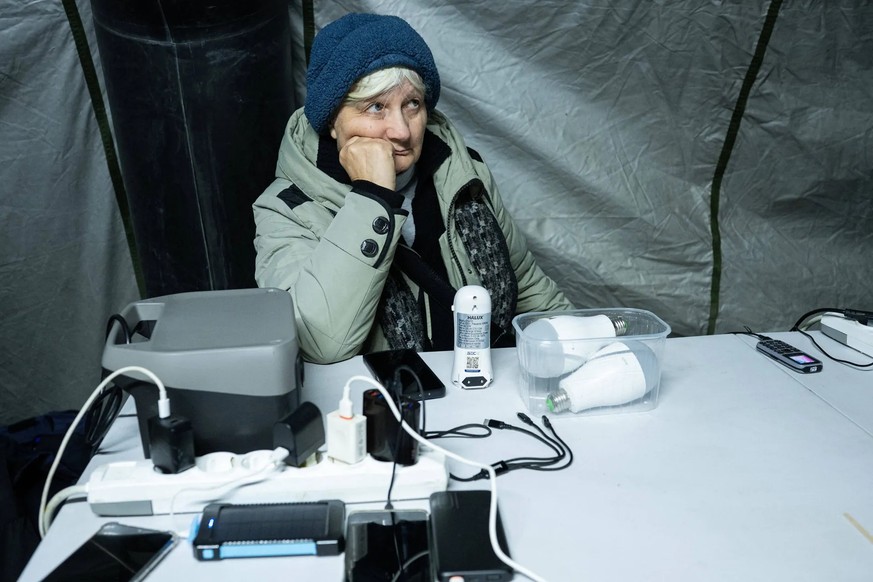 Une femme dans une tente chauffée à Kiev: les gens peuvent également y recharger leurs appareils électroniques.