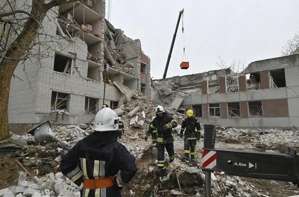 epaselect epa11284585 Ukrainian rescuers work at the site of a missile strike in Chernihiv, northern Ukraine, 17 April 2024, amid the Russian invasion. At least 17 people were killed and 60 others inj ...