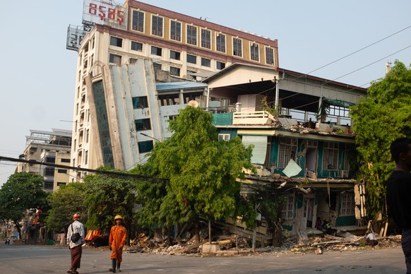 epaselect epa11996766 Rescuers walk in front of a damaged building following an earthquake in Mandalay, Myanmar, 29 March 2025. More than 1,000 people have been killed and thousands injured after a 7. ...