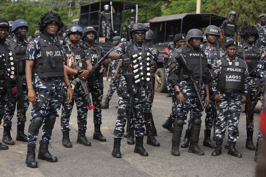 Nigeria police officers stand guard during a candle light procession in honour of all protesters killed nationwide at the recently economic hardship protest, in Lagos, Nigeria, Friday, Aug. 9, 2024. ( ...