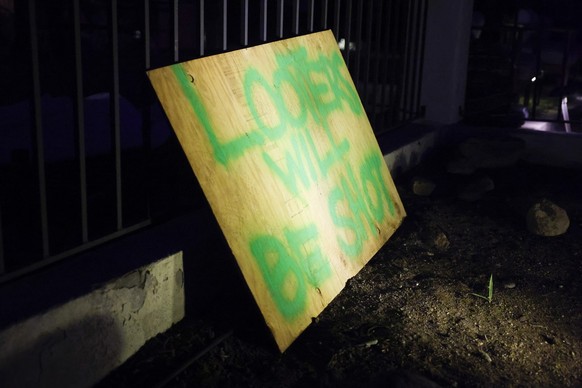 epa11822782 A sign that reads &#039;looters will be shot&#039; is posted outside of a house in Altadena, California, USA, 13 January 2025. Groups of people, despite evacuation notices, have stayed beh ...