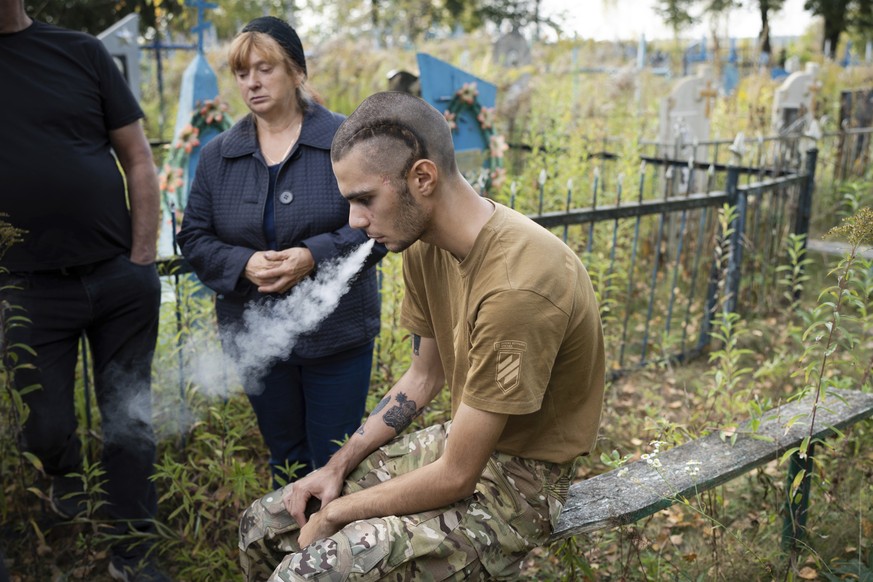 A Ukrainian soldier Pavlo &quot;Zhulik&quot; Sazonov smokes a cigarette after the funeral of his comrade, Andrii &quot;Adam&quot; Grinchenko of 3rd Assault Brigade, who was injured in the battle for A ...
