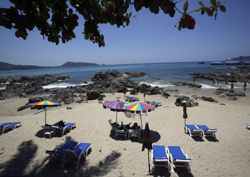 In this March 13, 2014, file photo, tourists spend time on Patong Beach in Phuket province, southern Thailand. Seeking to restart its big but battered tourist industry due to the coronavirus pandemic, ...