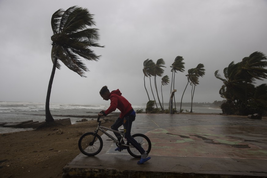 epa10194130 A cyclist observes the strong waves in Nagua, Dominican Republic, 19 September 2022. Hurricane Fiona, which has caused catastrophic damage in Puerto Rico a day earlier, has made landfall i ...