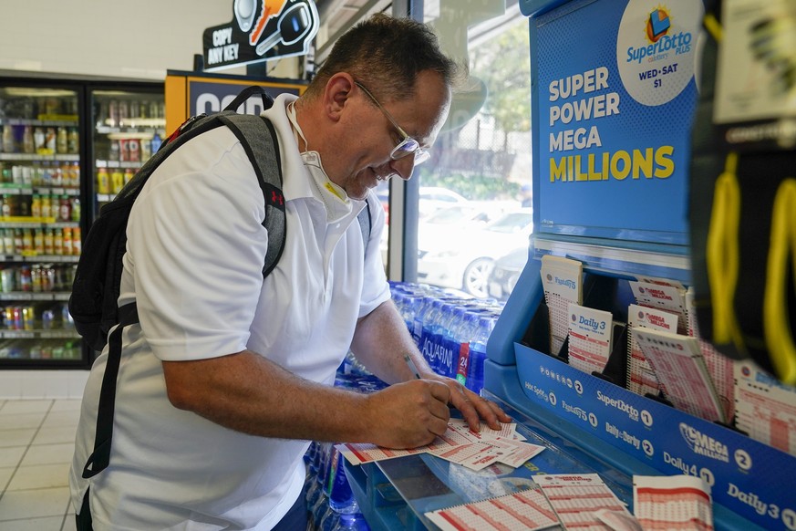 Gordon Midvale fills out a Mega Millions lottery ticket inside a 7-Eleven store in Oakland, Calif., Tuesday, July 26, 2022. (AP Photo/Godofredo A. Vásquez)