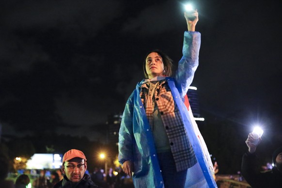 A demonstrator holds up her smart phone with the torch light switched on during an opposition protest against &quot;the Russian law&quot; near the Parliament building in the center of Tbilisi, Georgia ...