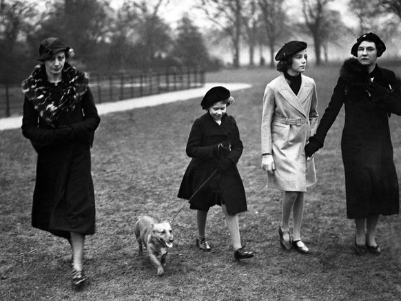 A young Queen Elizabeth taking her pet dog for a stroll through Hyde Park, London, on Feb. 26, 1936. She is in mourning for her beloved grandfather, King George, and is seen with a friend. (AP Photo)
