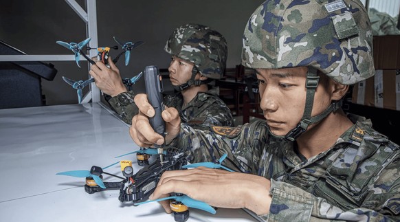 Deux soldats chinois s&#039;entraînent sur des drones militaires.
