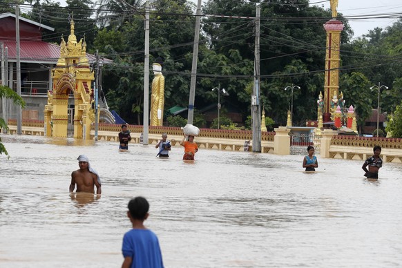 epaselect epa11603206 People carry their belongings at they wade through the flood in Taungoo, Bago division, Myanmar, 14 September 2024. Heavy rains triggered by Typhoon Yagi have caused severe flood ...