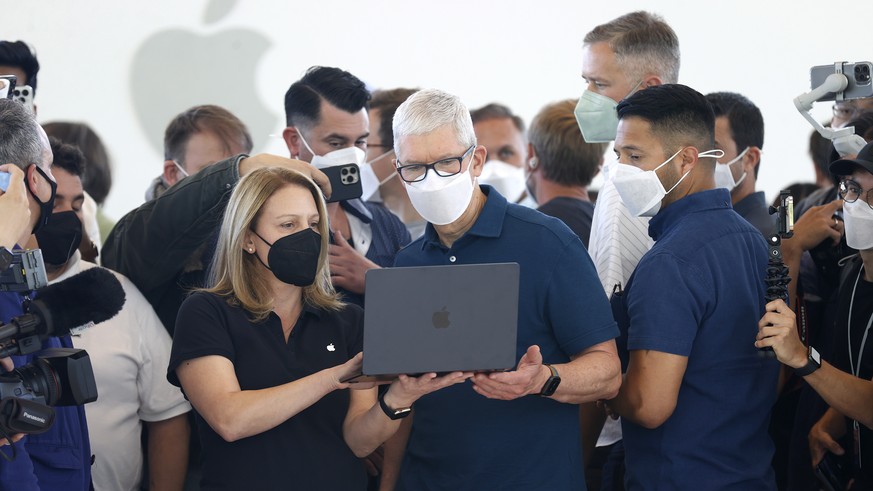 epa09999622 Apple CEO Tim Cook talks with an Apple employee during a media hands-on viewing of the new Apple MacBook Air M2 on display during the 2022 Apple Worldwide Developers Conference (WWDC) on t ...