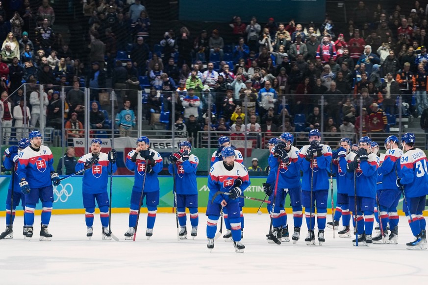 The Slovakia team stand on the ice after losing a men's ice hockey bronze medal game against Finland at the 2026 Winter Olympics, in Milan, Italy, Saturday, Feb. 21, 2026. (AP Photo/Petr David Jo ...