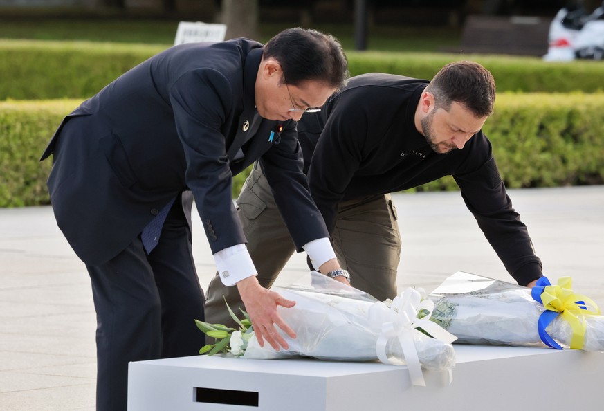 epa10643213 A handout photo made available by the G7 Hiroshima Summit Host shows Japan?s Prime Minister Fumio Kishida (L) and Ukraine&#039;s President Volodymyr Zelensky lay flowers in front of the Ce ...