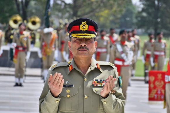FILE - In this photo released by the Inter Services Public Relations, newly elevated Field Marshal General Asim Munir prays after laying wreath on the Martyrs monument during a special guard of honor  ...