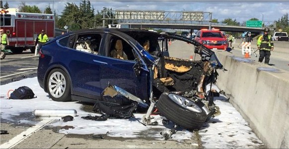 FILE - In this March 23, 2018, file photo provided by KTVU, emergency personnel work a the scene where a Tesla electric SUV crashed into a barrier on U.S. Highway 101 in Mountain View, Calif. The Appl ...