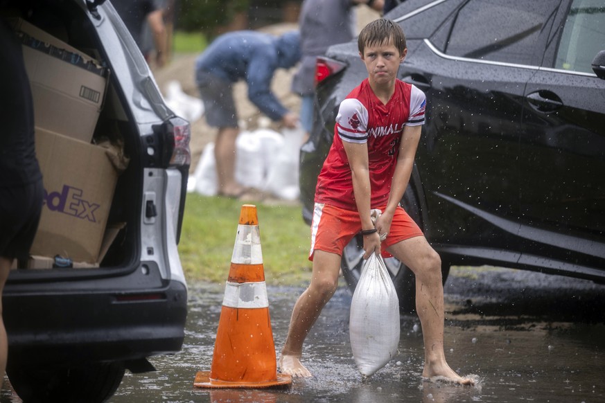 Brantley Schnabel helps his family carry sandbags to their van while preparing for Hurricane Debby at a county park, Monday, Aug. 5, 2024, in Savannah, Ga. Debby reached the Big Bend coast of Florida  ...