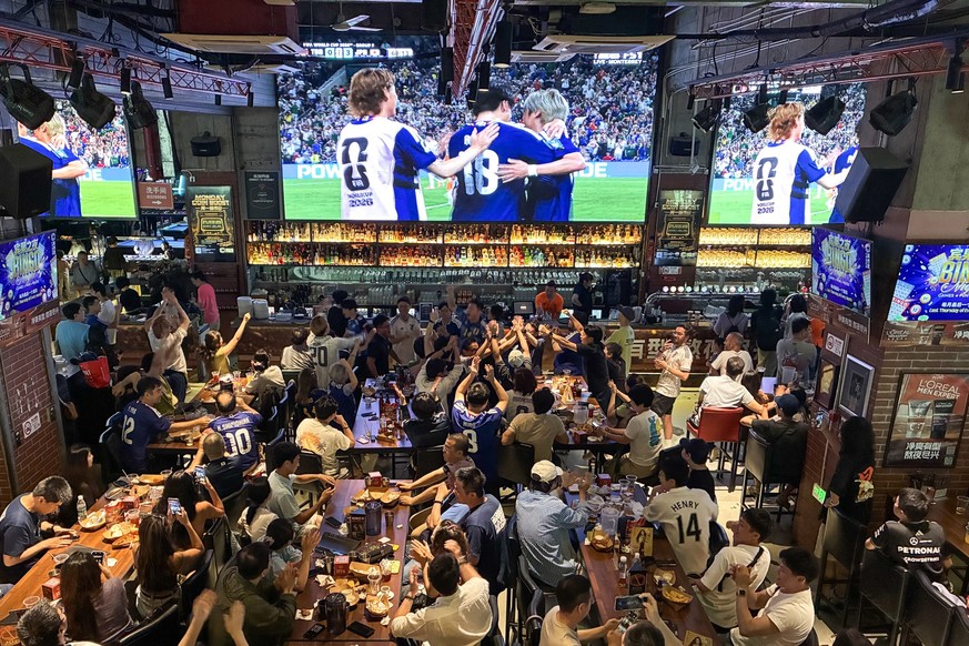 This photo taken on June 21, 2026 shows Chinese fans of the Japan football team watching the 2026 World Cup Group F football match between Japan and Tunisia at a bar in Shanghai, as the game takes pla ...
