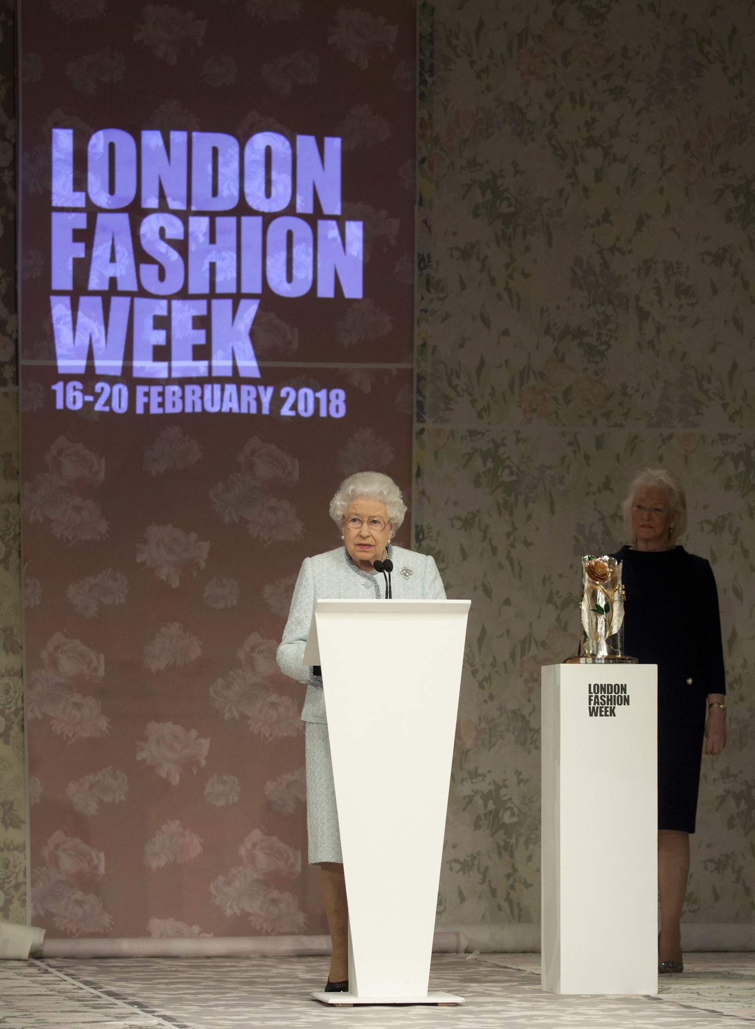 Queen Elizabeth II delivers a speech, watched by Angela Kelly, before presenting the inaugural Queen Elizabeth II Award for British Design to Richard Quinn following his Autumn/Winter 2018 London Fash ...