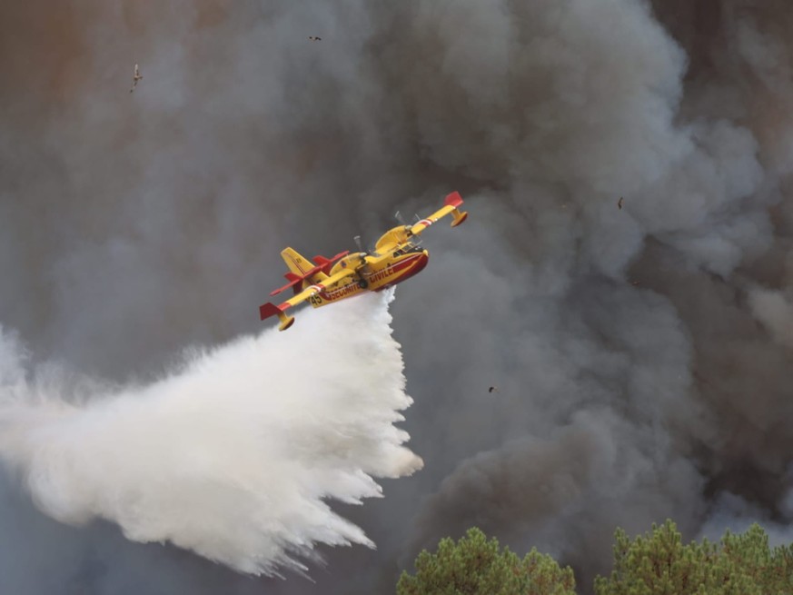 Un avion bombardier d'eau Canadair larguant de l'eau sur un incendie au camp de Souge, à Martignas-sur-Jalle, près de Bordeaux, dans le sud-ouest de la France le 28 juillet.