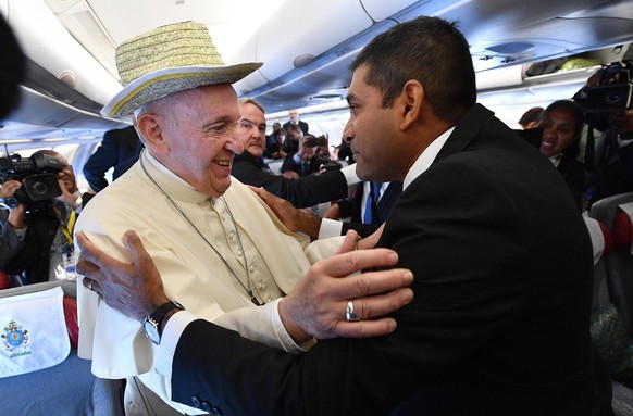 epa07817541 Pope Francis (L) wearing a typical hat from Rodrigues Island, gift of the journalists aboard of a flight from Italy to Mozambique, 04 September 2019. Pope Francis will visit Mozambique, Ma ...