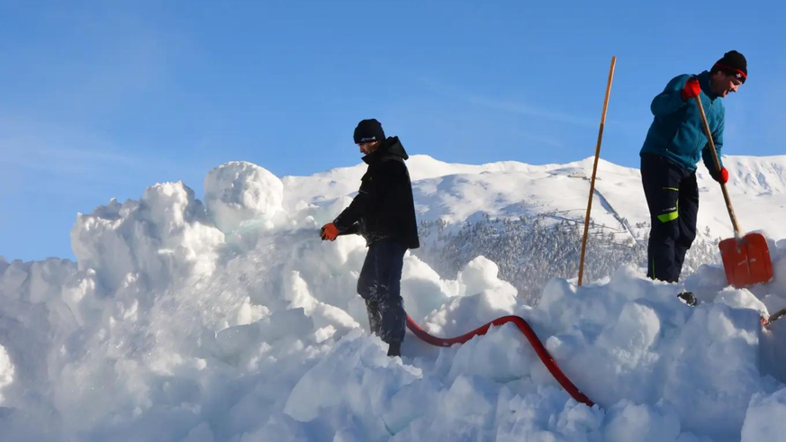 Les travailleurs s'attachent à imbiber la neige d'eau.