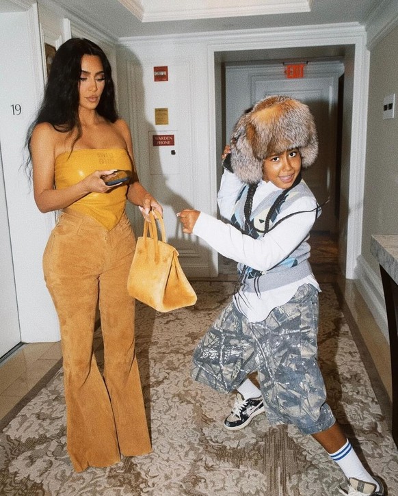 Kim Kardashian et sa fille North dans un couloir d'hôtel.